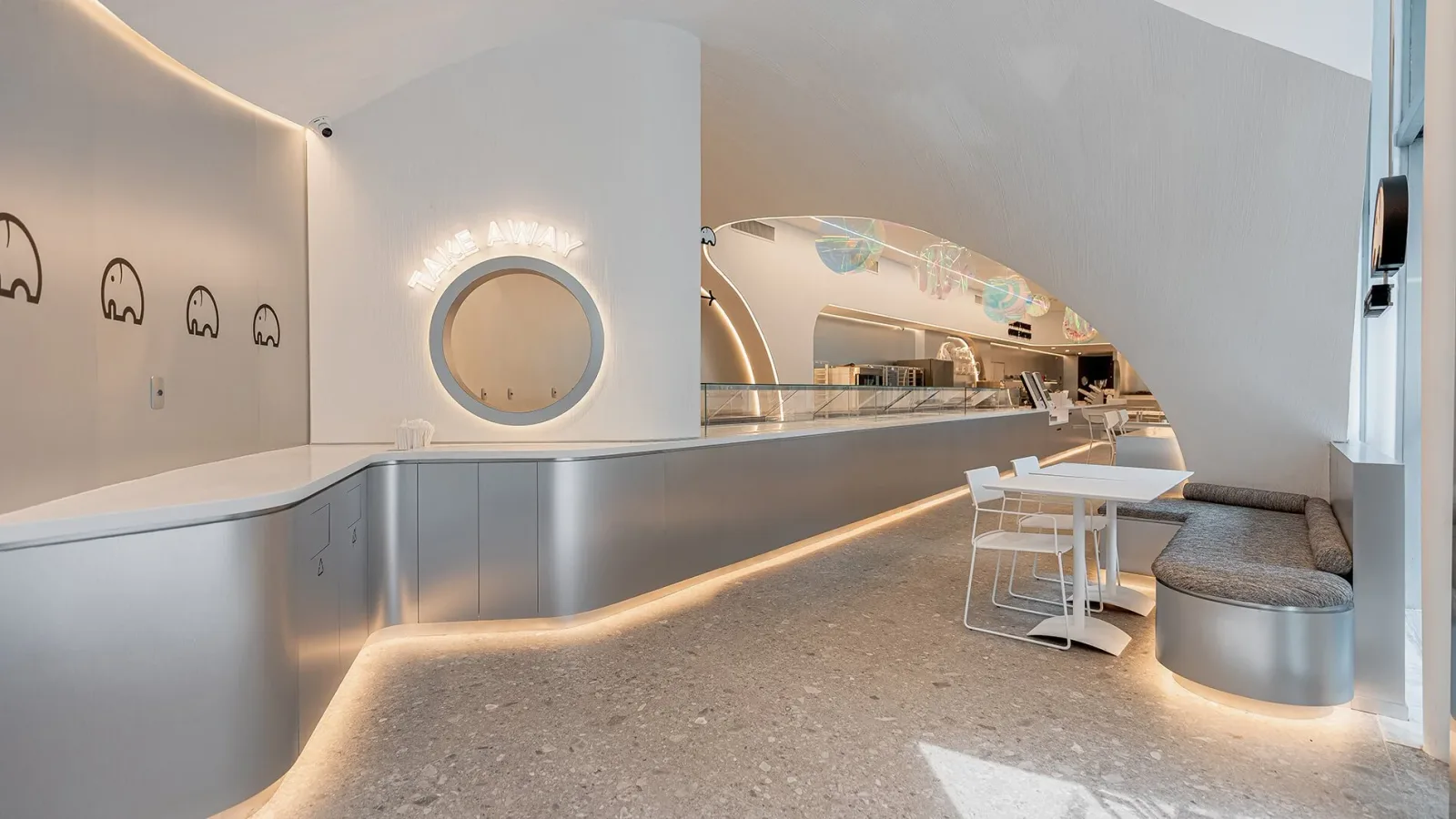 modern minimalist interior with curved counters, circular mirror, and soft ambient lighting throughout., we coffee av. paulis