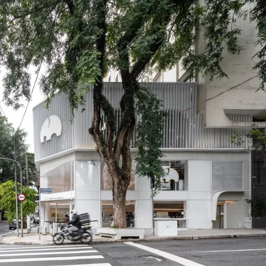 modern white building with large mature tree and street-level storefront entrance., we coffee av. paulista, são paulo