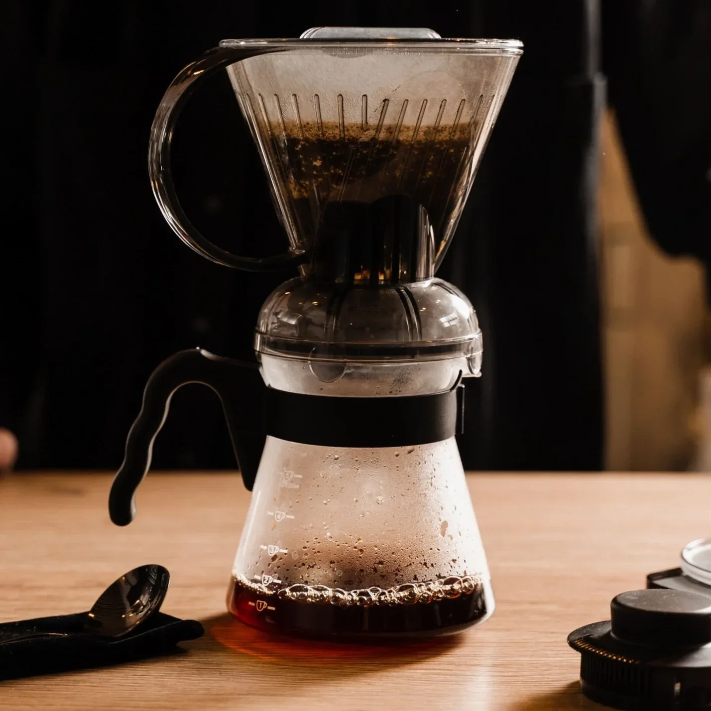 pour-over coffee maker with brewed coffee on wooden table surface., weathered hands coffee, austin