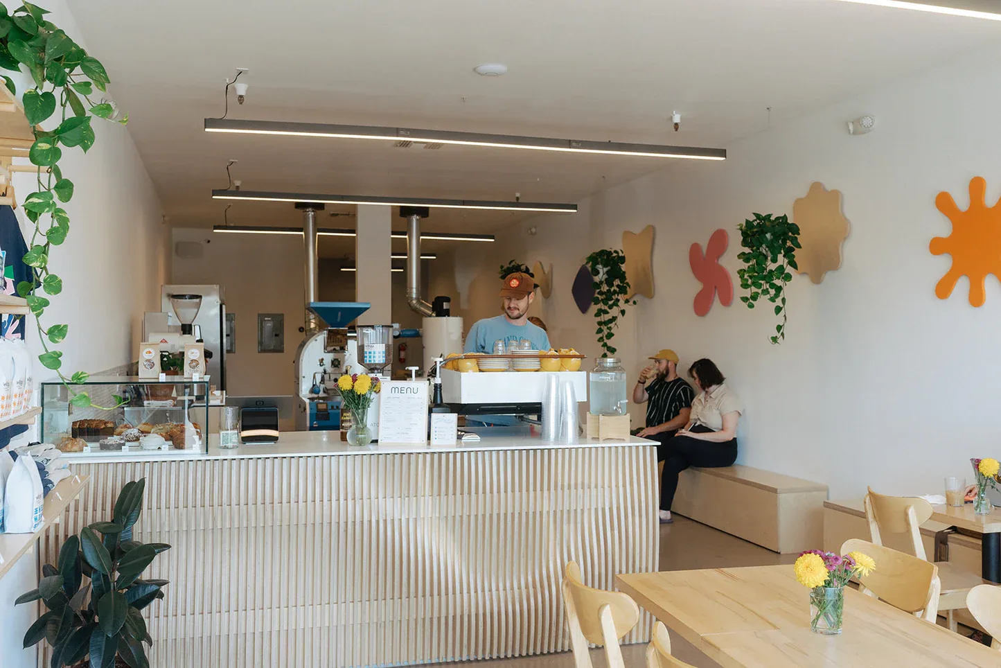 modern bright café interior with counter service, wooden tables, and decorative wall plants., webe coffee roasters, phoenix