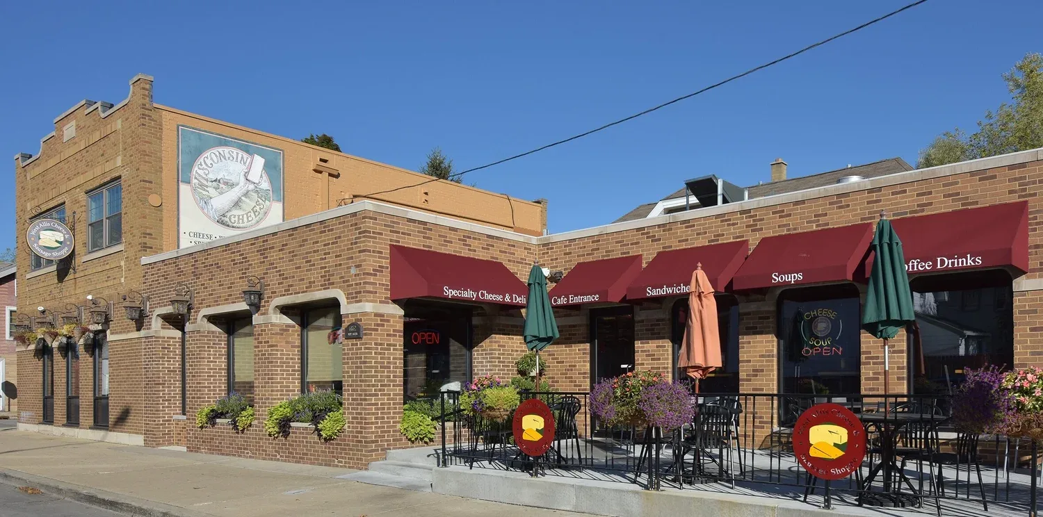 wisconsin cheese shop and café with burgundy awnings, outdoor seating, and signage., west allis cheese & sausage shoppe, west