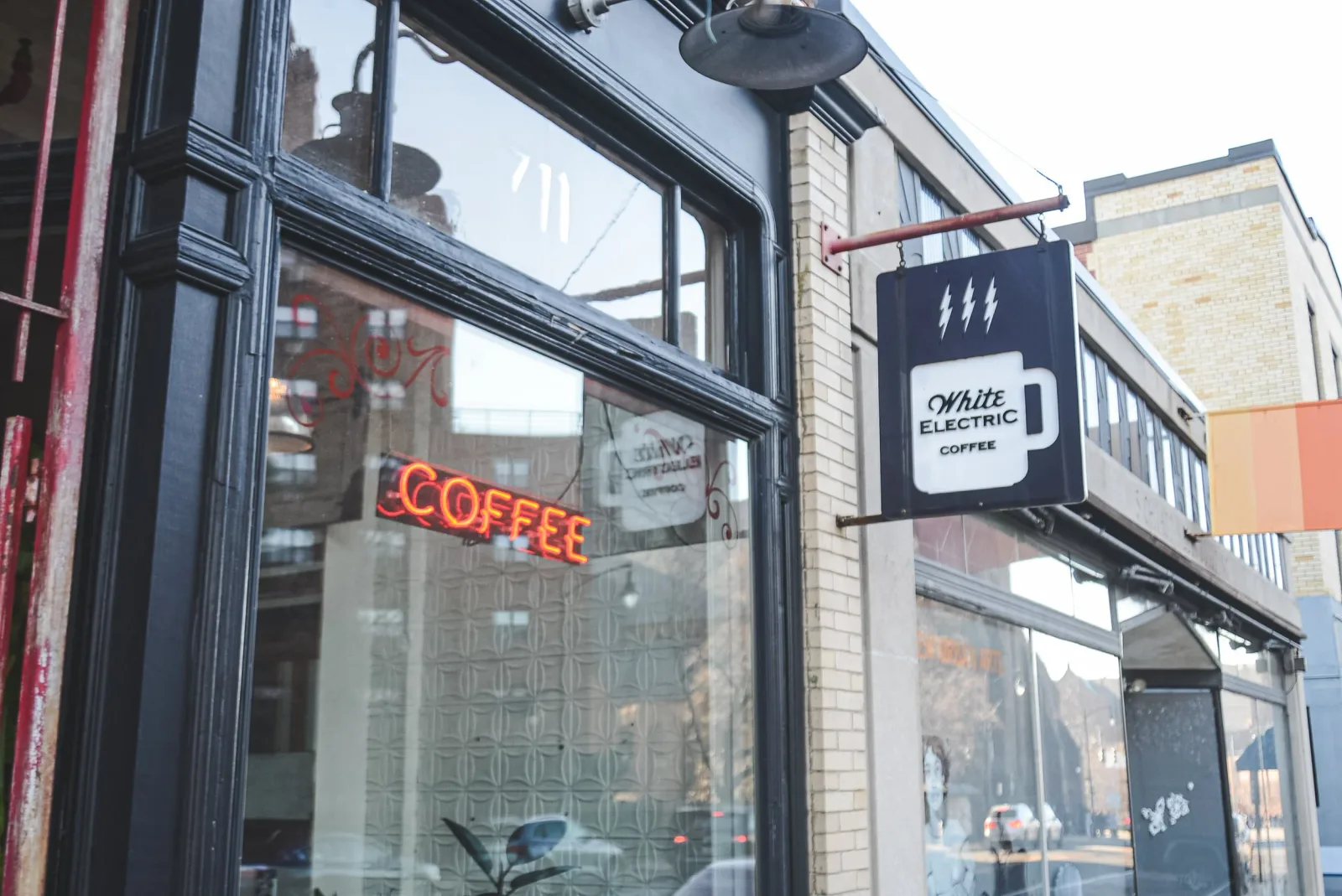 white electric coffee shop storefront with neon sign and hanging signage., white electric coffee, rhode island
