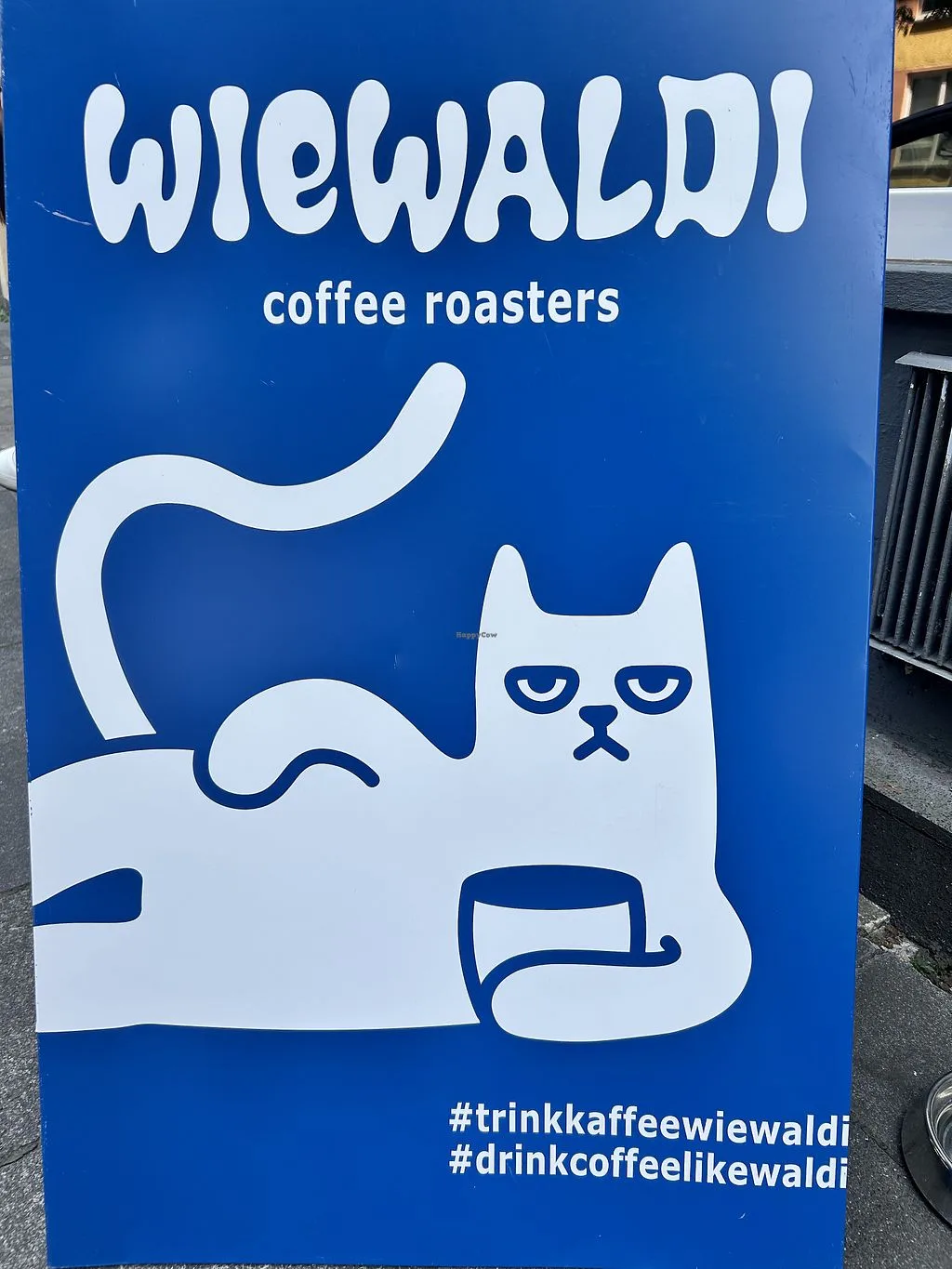 blue sign for wiewaldi coffee roasters featuring a minimalist white cat holding a coffee cup., wiewaldi coffee roasters, colo