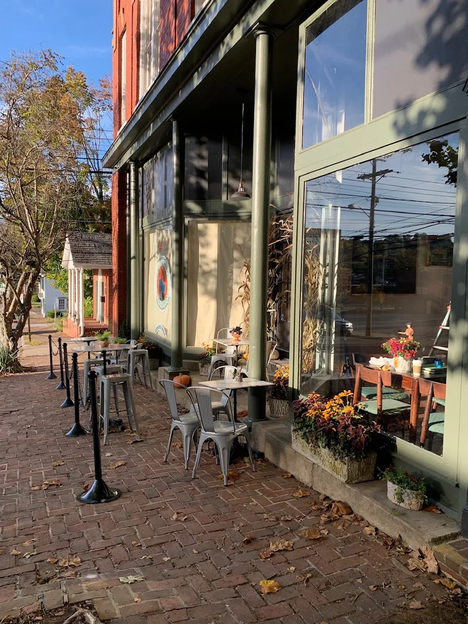 brick storefront patio with metal chairs, fall decorations, and flowering plants., wolf hills coffee, abingdon