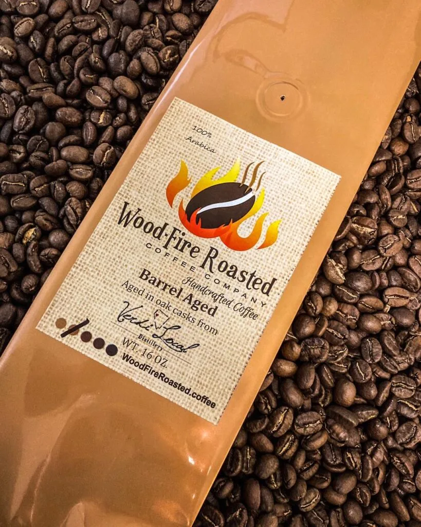 wood-fire roasted coffee bag displayed on bed of dark roasted beans., wood-fire roasted coffee company, reno