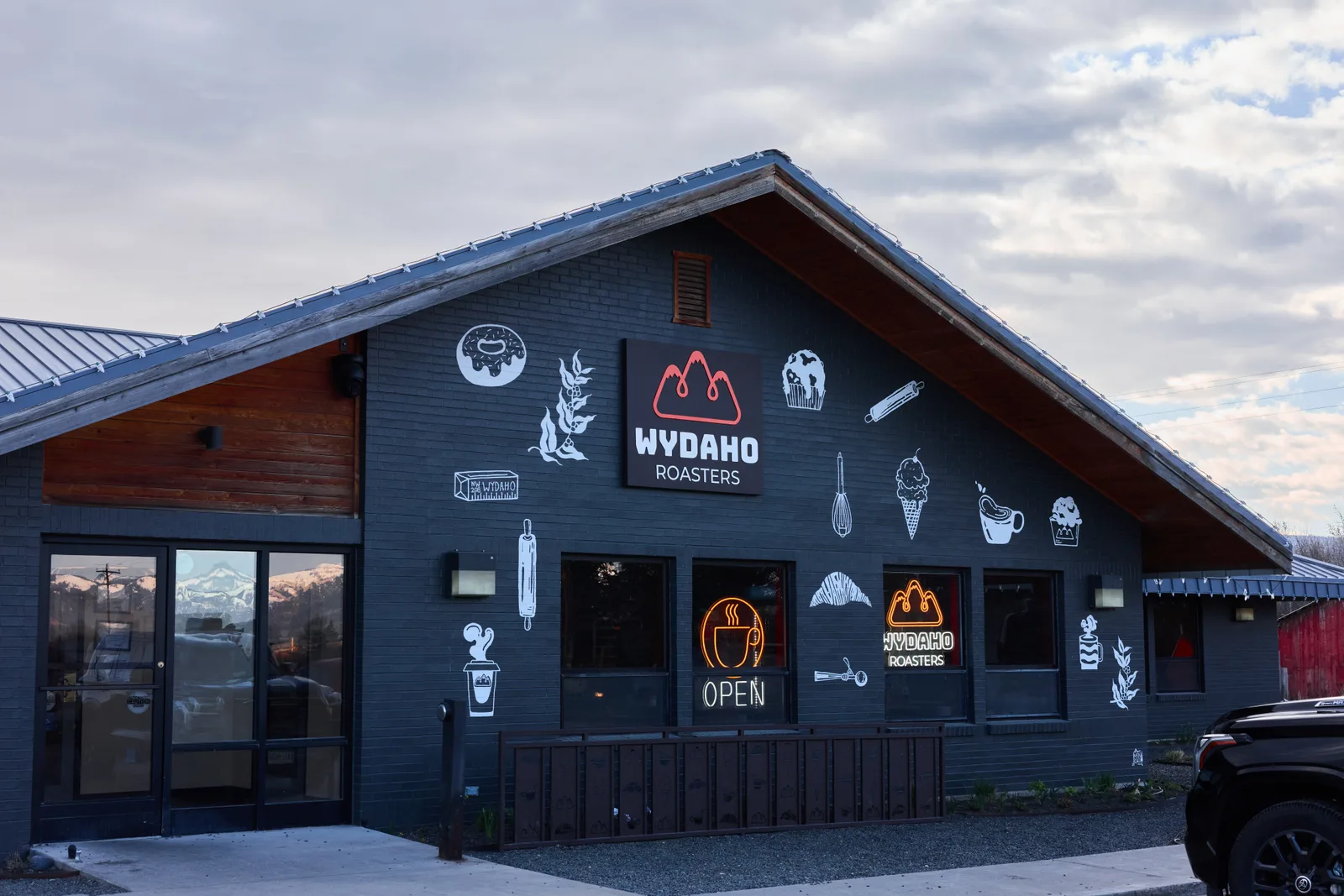 dark blue building with red roof featuring wydaho roasters signage and coffee-themed artwork., wydaho roasters, driggs