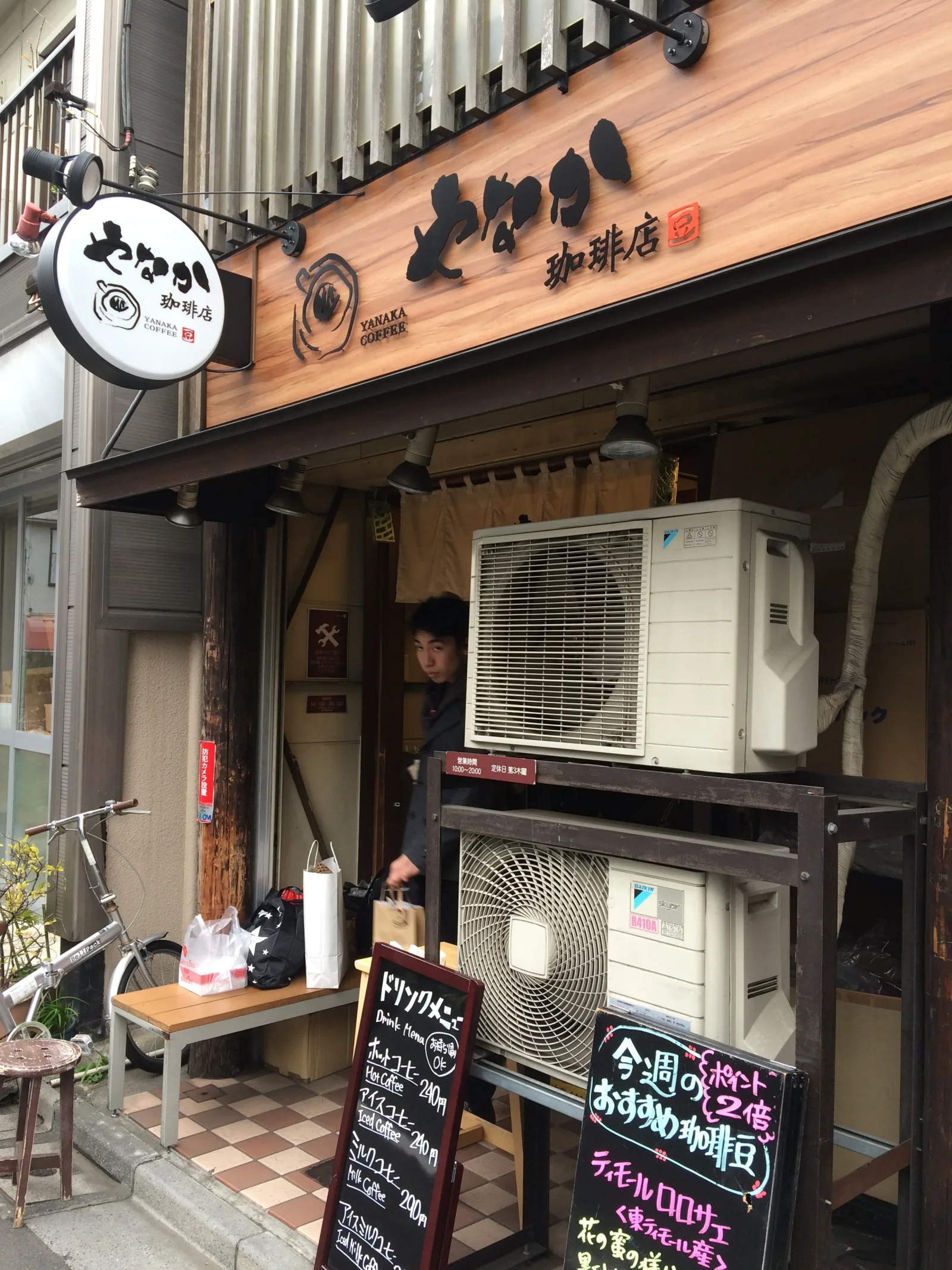japanese coffee shop storefront with wooden signage and air conditioning units., yanaka coffee-ten yanaka shop, tokyo