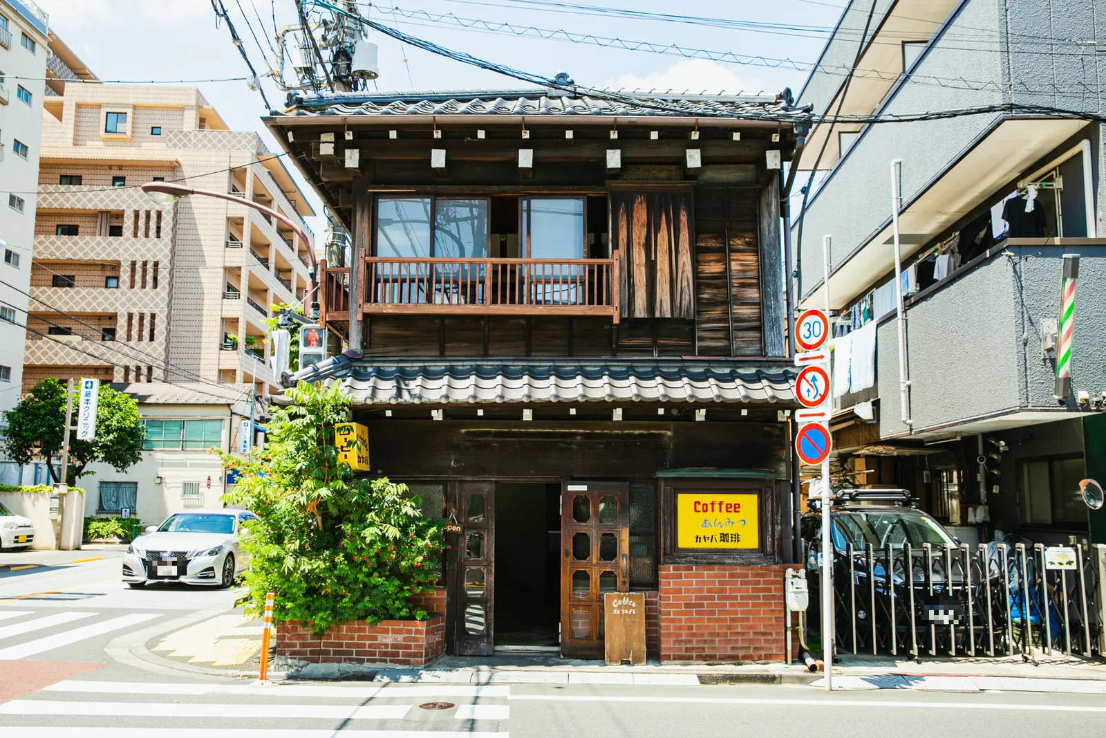 traditional japanese wooden building with coffee shop nestled among modern urban structures., yanaka coffee-ten yanaka shop, 