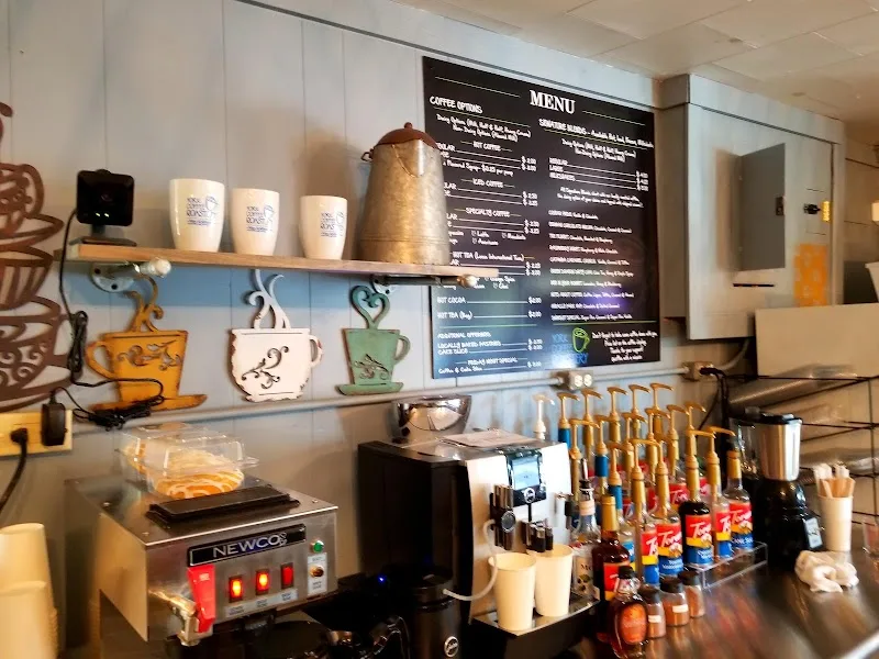 coffee shop counter with menu board, equipment, cups, syrups, and decorative mugs., york coffee roastery, south carolina