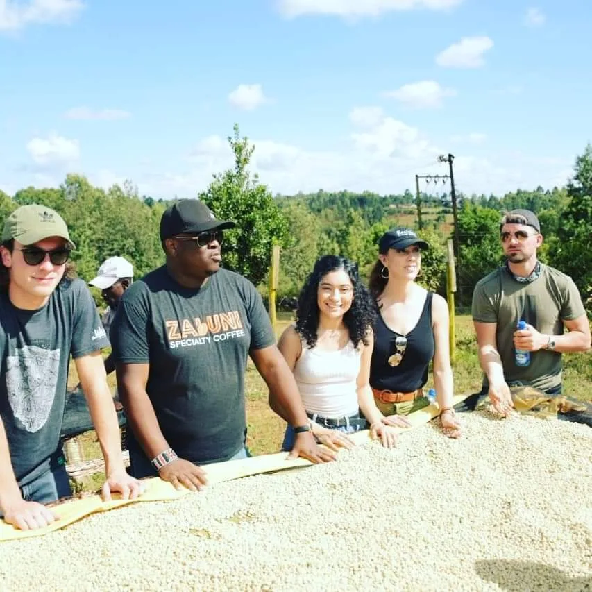 group of people gathered around a table at an outdoor agricultural site., zabuni coffee, nebraska